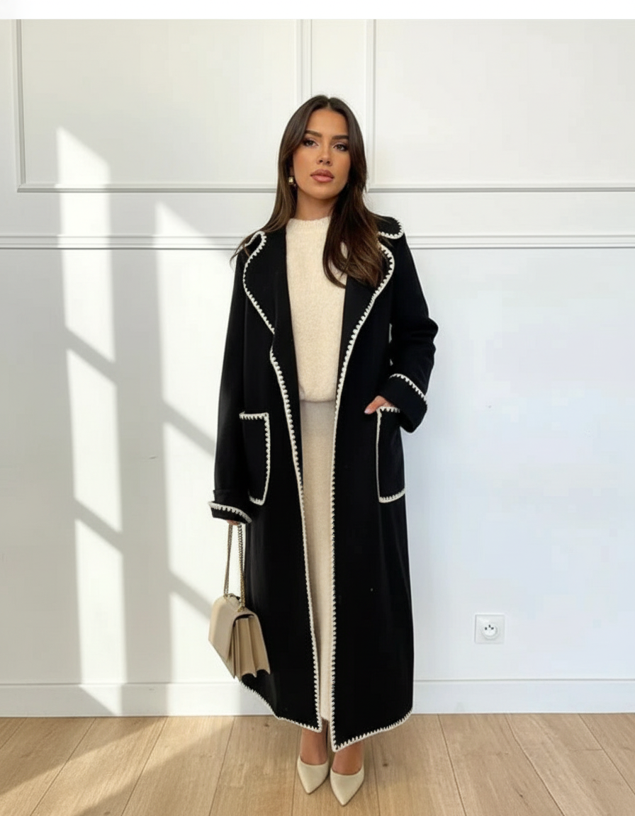 Modellbild av svart kappa med vit kontrastsöm